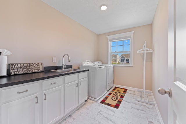 washroom featuring a textured ceiling, cabinets, washer and dryer, and sink