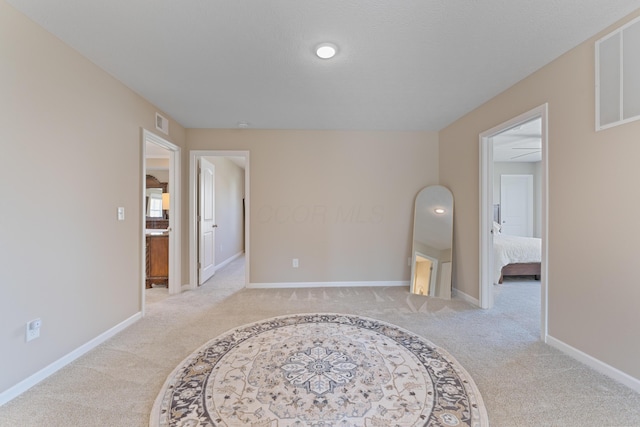 spare room featuring ceiling fan and light colored carpet