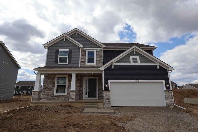 craftsman inspired home featuring a porch, stone siding, a garage, and driveway