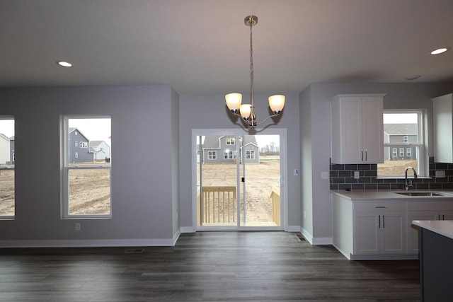 kitchen with a sink, light countertops, white cabinetry, and plenty of natural light