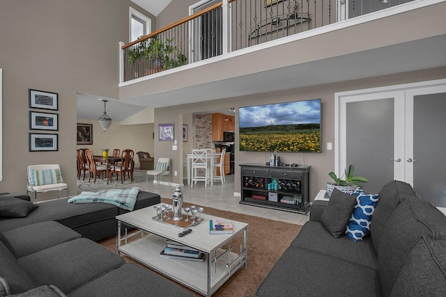 living room featuring a high ceiling, tile patterned floors, and french doors