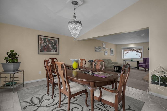 tiled dining area featuring an inviting chandelier and vaulted ceiling