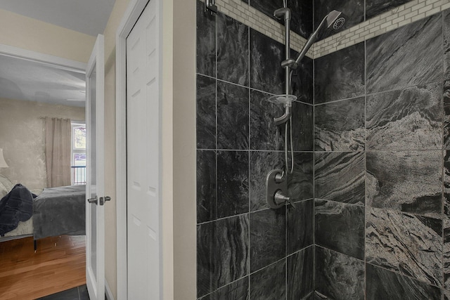 bathroom featuring hardwood / wood-style flooring and tiled shower