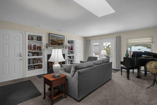 carpeted living room featuring a skylight and built in features