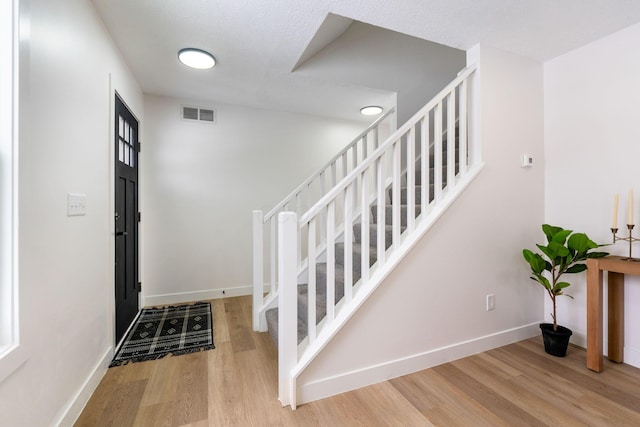 entryway featuring a textured ceiling and hardwood / wood-style flooring