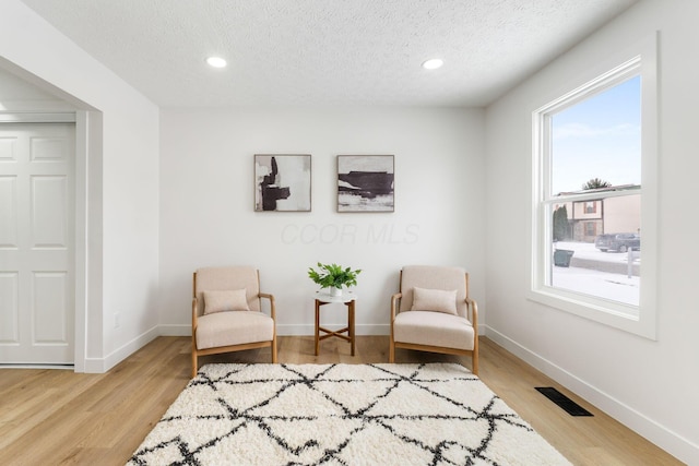 sitting room featuring a textured ceiling and hardwood / wood-style flooring