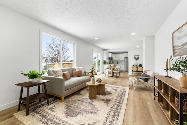 living room featuring a textured ceiling and light wood-type flooring