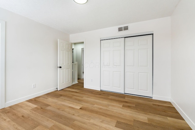 unfurnished bedroom featuring a closet and light hardwood / wood-style floors