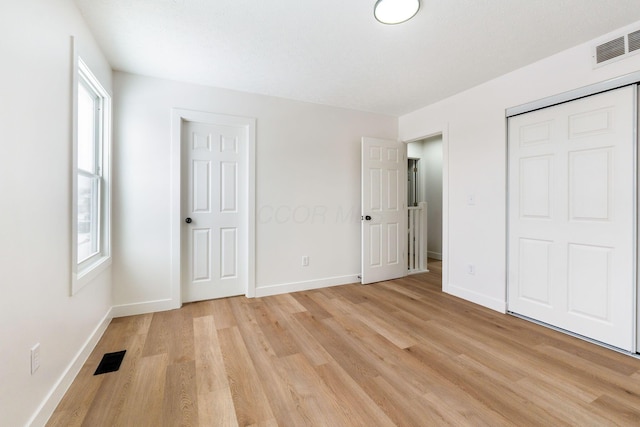 unfurnished bedroom with multiple windows and light hardwood / wood-style flooring