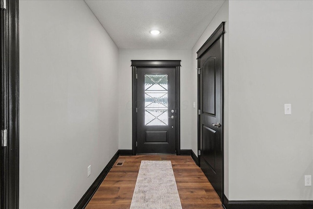 entryway with dark wood-type flooring and a textured ceiling