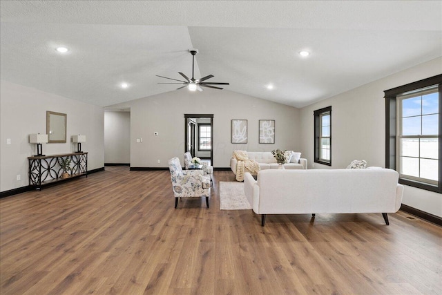 living room featuring a textured ceiling, ceiling fan, lofted ceiling, and wood-type flooring