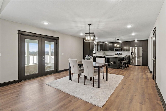 dining space featuring hardwood / wood-style floors, a textured ceiling, and french doors