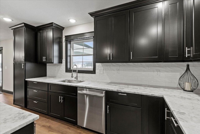 kitchen with light wood-type flooring, dishwasher, light stone counters, and sink