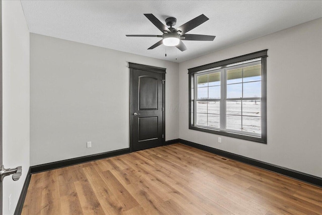 empty room featuring ceiling fan, a textured ceiling, and light hardwood / wood-style flooring