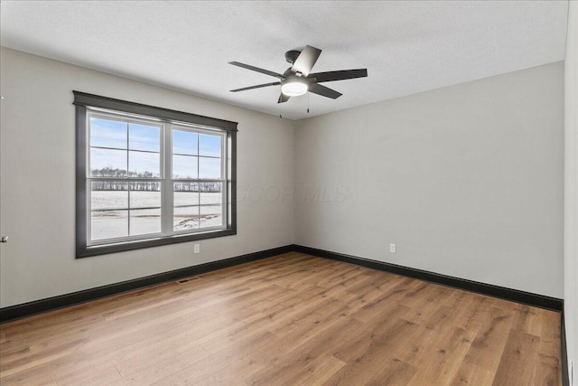 spare room with ceiling fan, a textured ceiling, and light hardwood / wood-style flooring