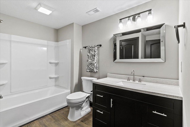 full bathroom with a textured ceiling, vanity, toilet, hardwood / wood-style flooring, and  shower combination