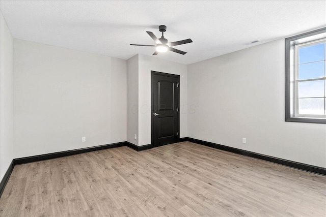 spare room featuring ceiling fan, light wood-type flooring, and a textured ceiling