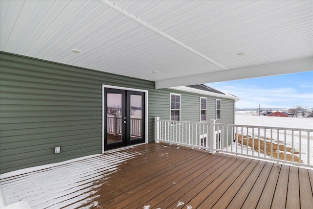 snow covered deck with french doors