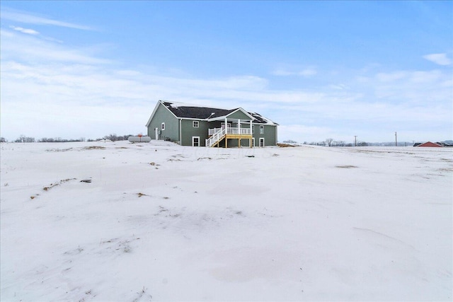 snow covered house with a wooden deck