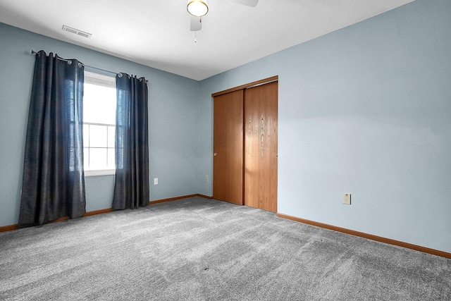 unfurnished bedroom featuring visible vents, baseboards, a closet, and carpet flooring