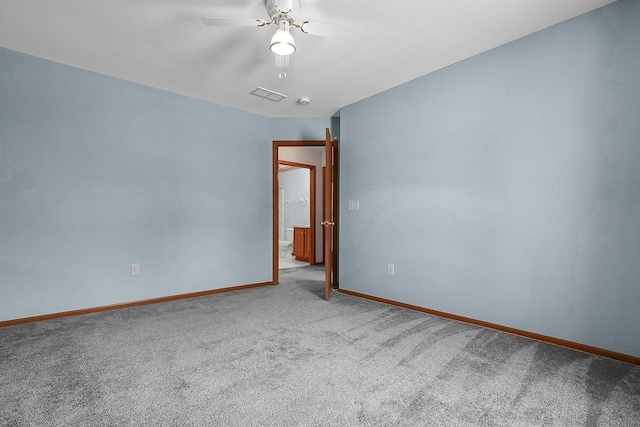 empty room with carpet, visible vents, a ceiling fan, and baseboards