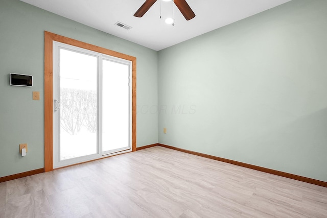 spare room with ceiling fan, a wealth of natural light, and light hardwood / wood-style flooring