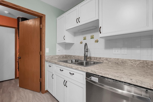 kitchen featuring decorative backsplash, dishwasher, white cabinets, and sink