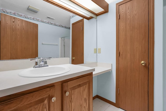 bathroom featuring a shower with door and vanity