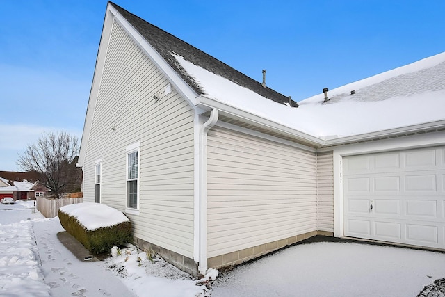 view of snowy exterior featuring a garage