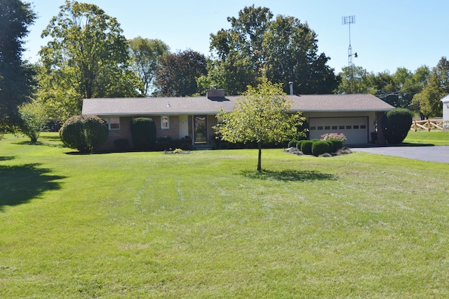 single story home featuring a garage and a front lawn