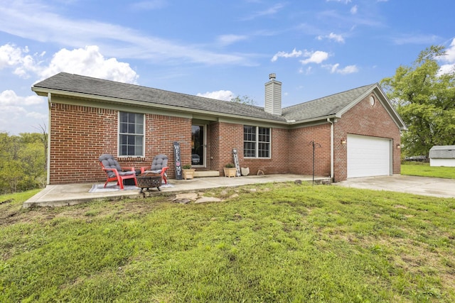 back of property featuring a yard, a patio, a fire pit, and a garage