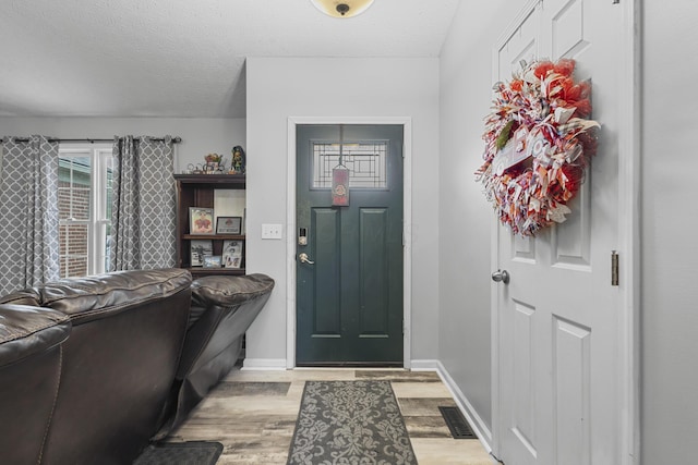 entrance foyer with a textured ceiling and light wood-type flooring