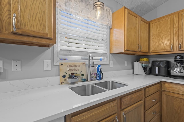 kitchen featuring a textured ceiling and sink