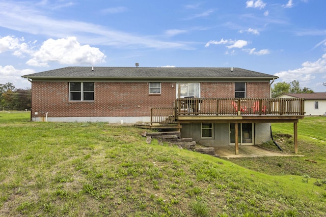 back of property with a wooden deck, a patio area, and a yard