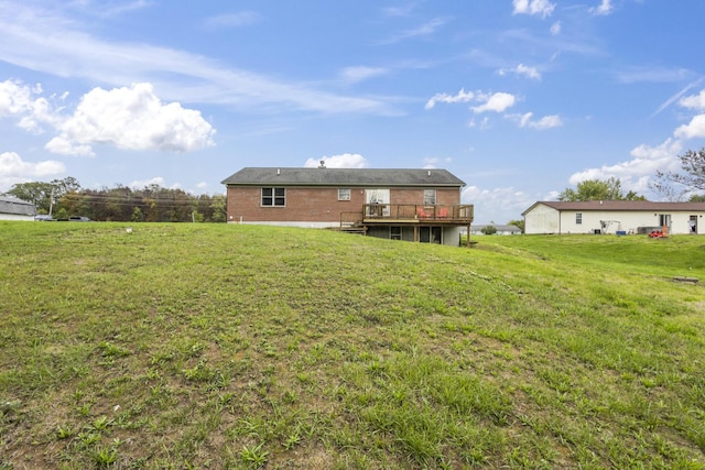 back of house featuring a deck and a lawn