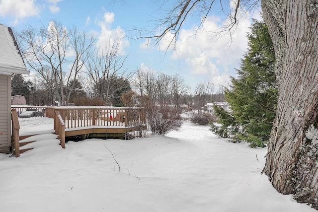 snowy yard featuring a deck