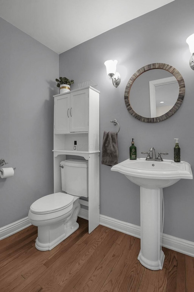 bathroom with toilet and hardwood / wood-style flooring