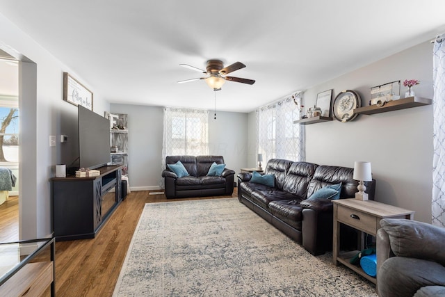 living room featuring ceiling fan and dark hardwood / wood-style flooring