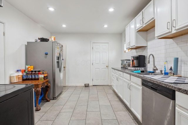 kitchen with white cabinets, stainless steel appliances, decorative backsplash, sink, and light tile patterned flooring