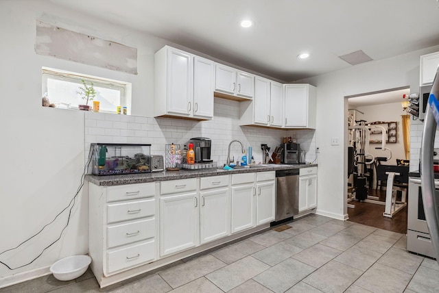 kitchen with decorative backsplash, sink, white cabinets, and dishwasher