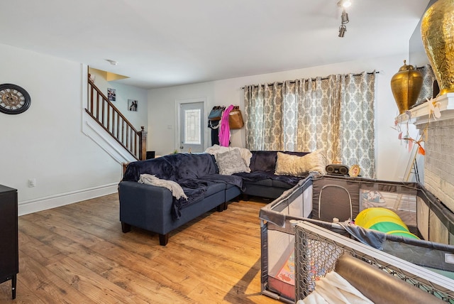 living room featuring a brick fireplace and wood-type flooring