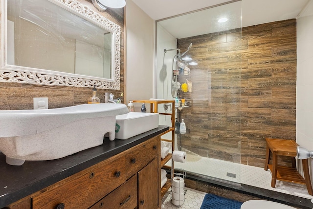 bathroom with tile patterned flooring, vanity, tasteful backsplash, tile walls, and a tile shower