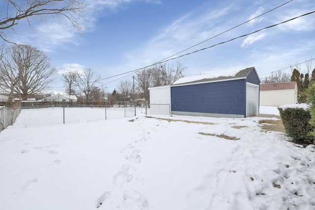 yard covered in snow featuring a garage and an outdoor structure