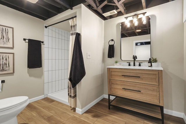 bathroom featuring toilet, vanity, and curtained shower