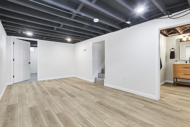 basement with light hardwood / wood-style floors