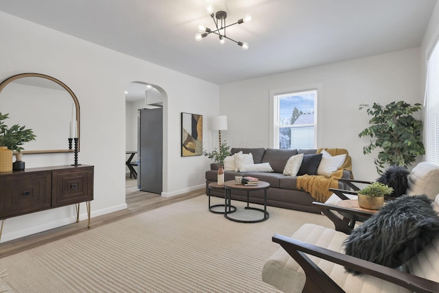 living room with light wood-type flooring and a chandelier