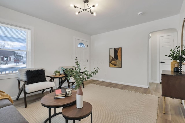 living room with a notable chandelier and light hardwood / wood-style flooring