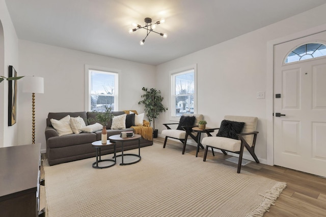 living room with light wood-type flooring and an inviting chandelier