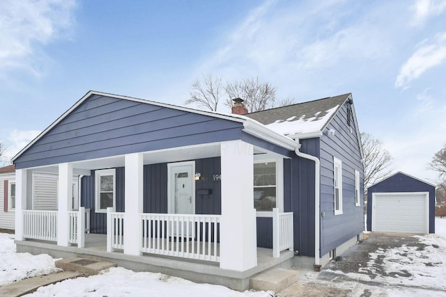 view of front of house featuring a garage, an outdoor structure, and a porch