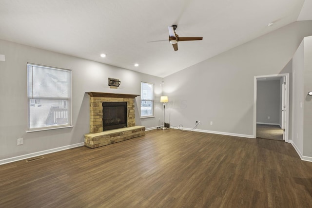 unfurnished living room with ceiling fan, dark hardwood / wood-style flooring, lofted ceiling, and a fireplace